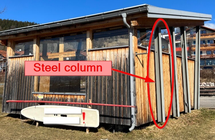 Steel column with H/I section supporting wooden roof.